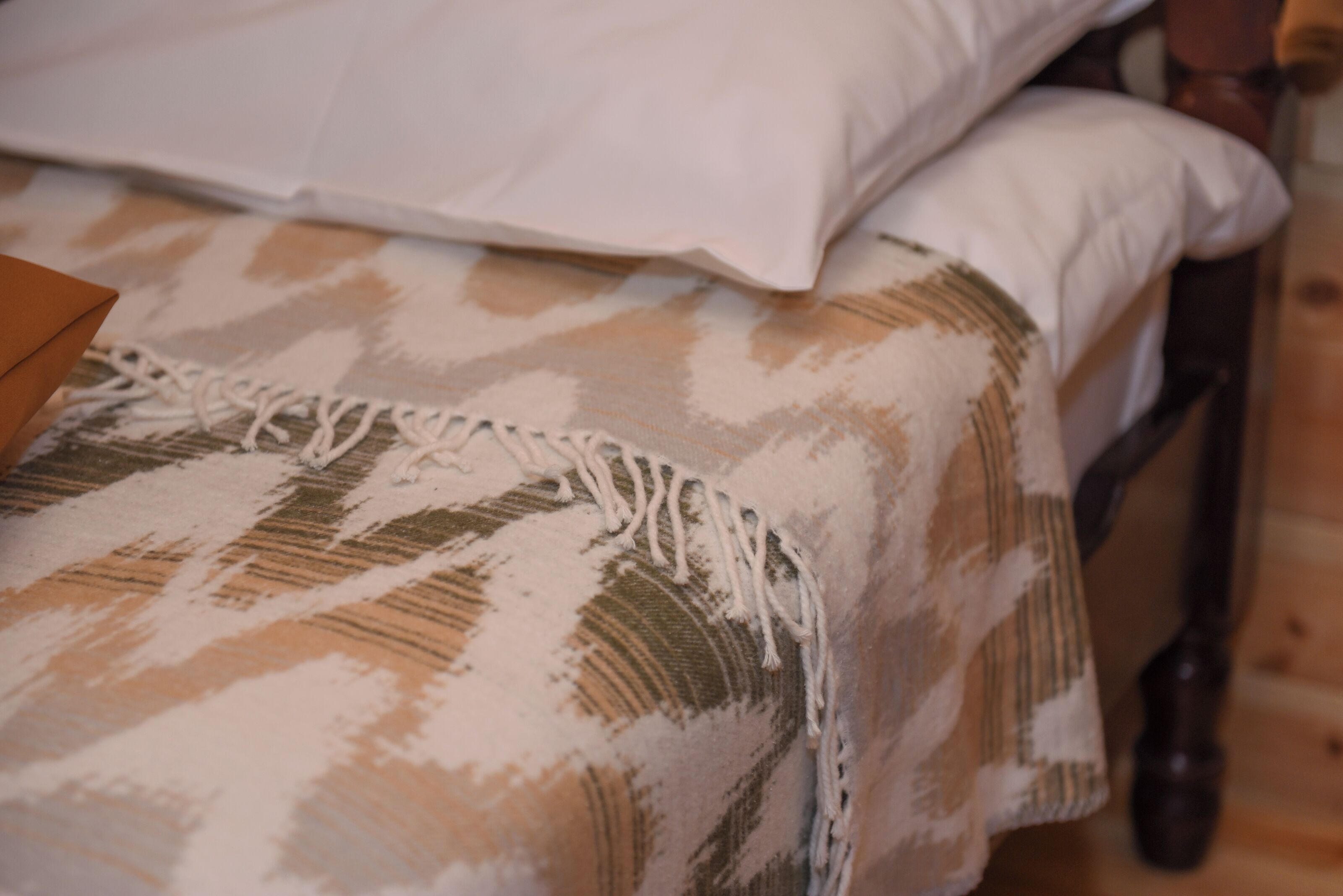 A bed with a patterned bedspread and pillows.