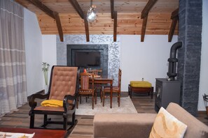 A living room with a fireplace, wooden furniture, and a television.