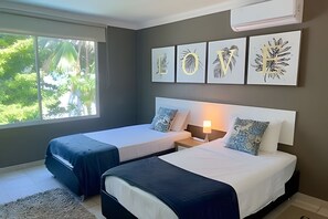 A hotel room with two beds, a nightstand, a lamp, and artwork on the wall. - Lagomar House: Private Pool, BBQ & Beach (Santa Marta)
