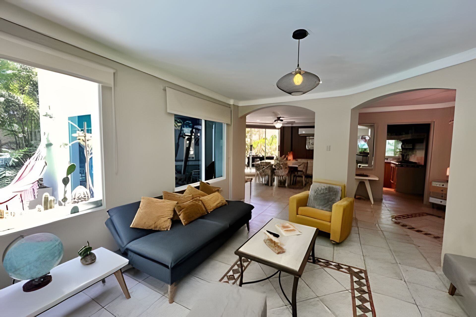 A living room with a sofa, a coffee table, and a dining area with chairs and a table.
