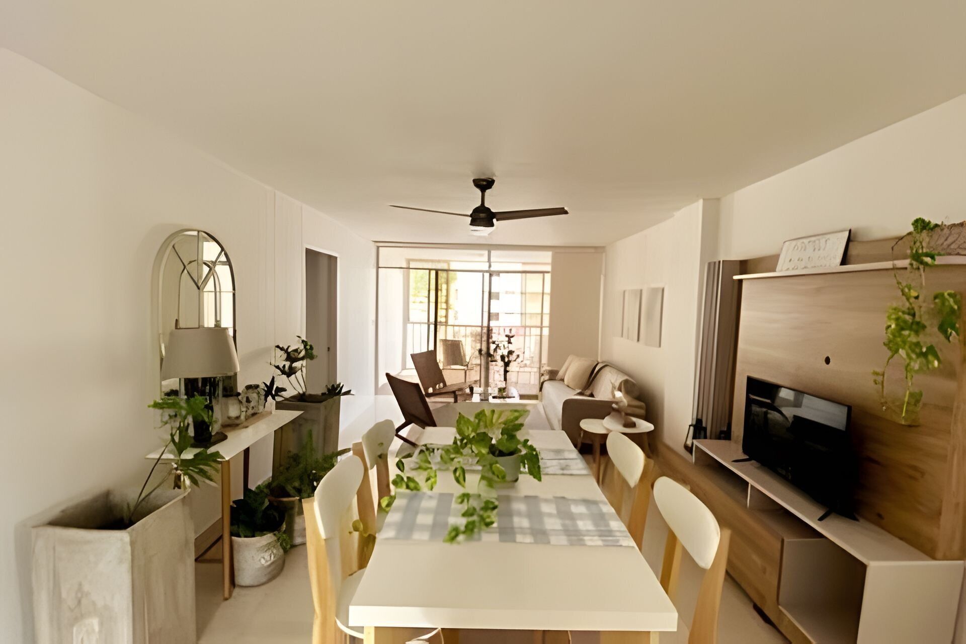 A modern living room with a dining area, a ceiling fan, and a TV.