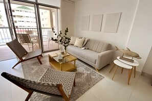 Ein modernes Wohnzimmer mit einer Couch, Sesseln, einem Couchtisch und einer dekorativen Fischskulptur.