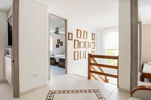 Ein Hotelzimmer mit einer Holztreppe, einem Fliesenboden und einer Wand mit gerahmten Bildern.