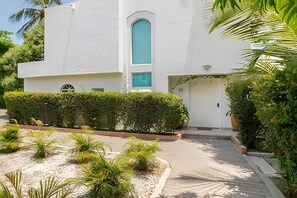 A modern building with a white exterior, a central arched window, and a door with a small overhang. - Relax: Beach House w/ Private Pool & Sea Access (Santa Marta)