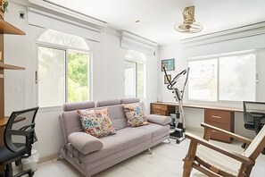 Ein modernes Wohnzimmer mit einer Couch, einem Schreibtisch und einem Sessel.