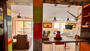 Una cocina moderna con comedor, una barra con taburetes y vistas al exterior.