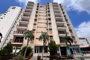 A multi-story residential building with balconies, a ground-level entrance, and a visible storefront. - Steps to the Beach: Family Apt in El Rodadero (Santa Marta)