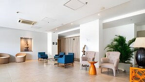 Eine geräumige Lobby mit moderner Einrichtung, einer großen Pflanze und einer dekorativen Lampe.