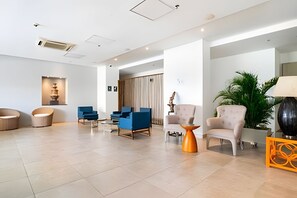 A spacious lobby with modern furniture, a large plant, and a decorative lamp. - Bello Horizonte: Modern Loft w/ Pool & Beach (Santa Marta)