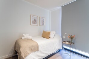 A bedroom with a bed, pillows, a bedside table with a lamp, and framed pictures on the wall. - R. Lyon Apartments by Andes STR (Providencia)