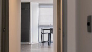 A hallway with a ceiling light fixture, a door, and a window with a view. - R. Lyon Apartments by Andes STR (Providencia)