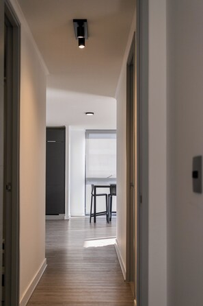 A hallway with a ceiling light fixture, a door, and a window with a view. - R. Lyon Apartments by Andes STR (Providencia)