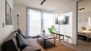 A modern living room with a sofa, coffee table, and a flat-screen TV mounted on the wall. - R. Lyon Apartments by Andes STR (Providencia)