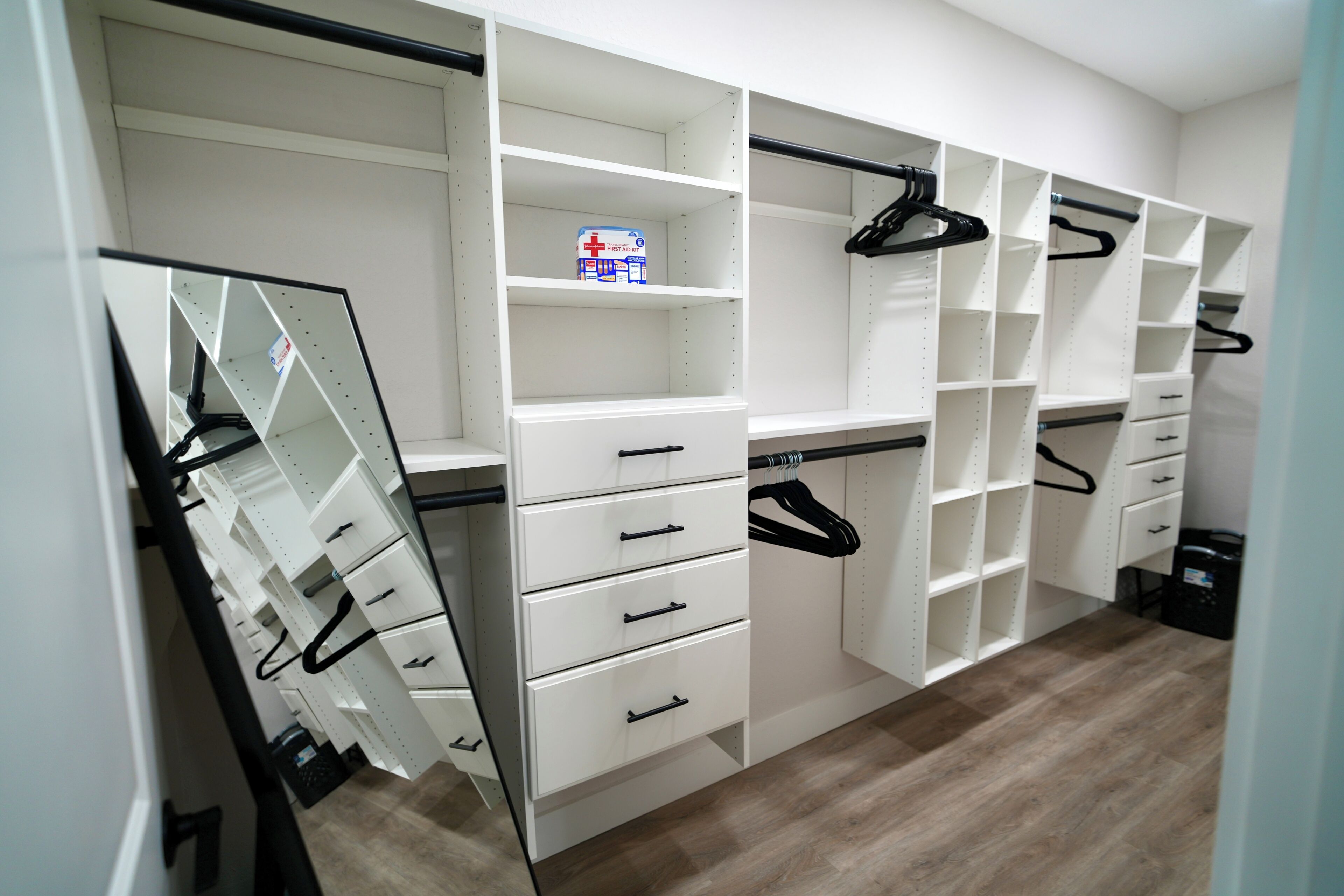A walk-in closet with open shelving, drawers, and hanging space.