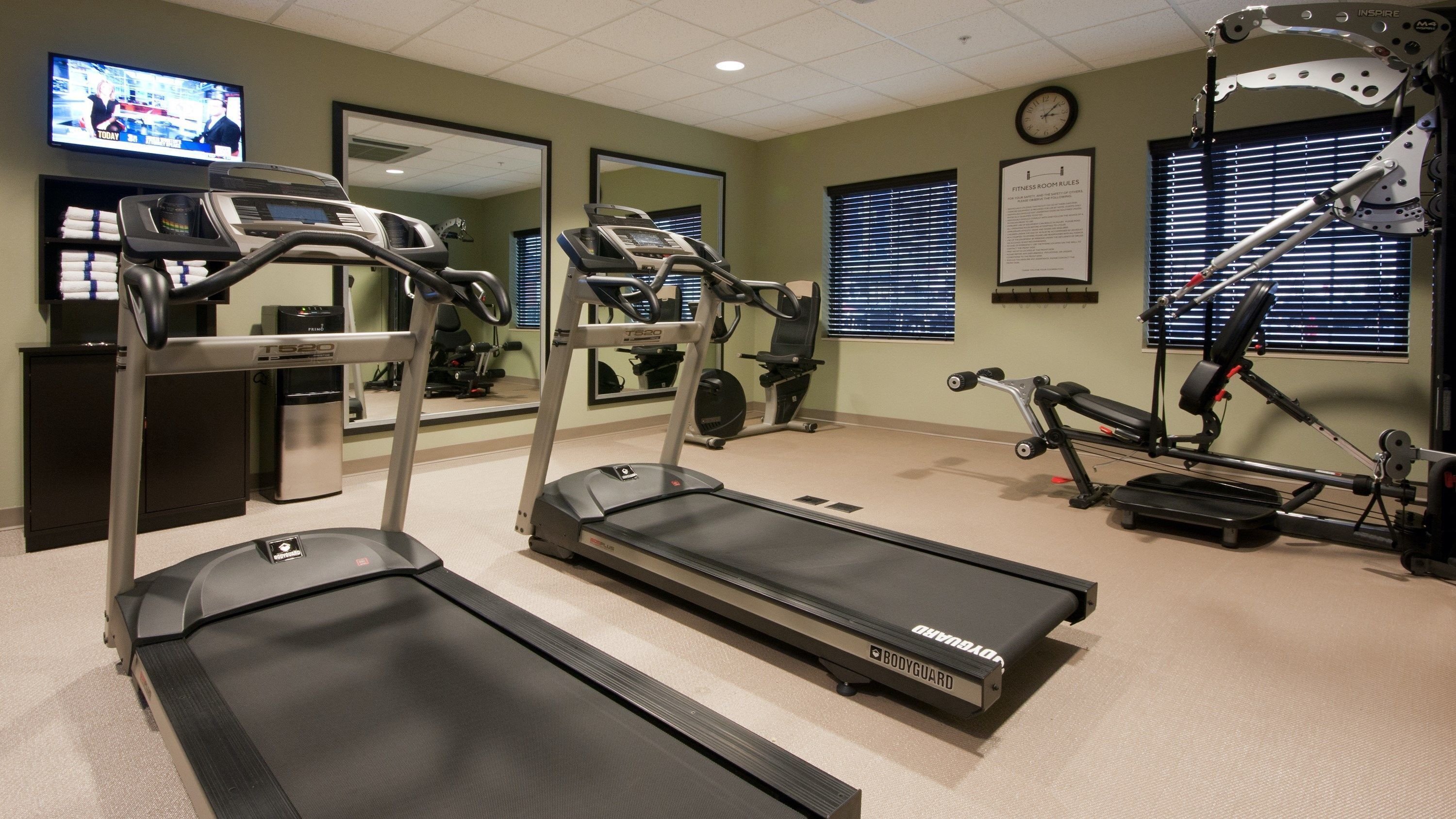 A fitness room with treadmills, elliptical machines, and a rowing machine.