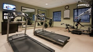 A fitness room with treadmills, elliptical machines, and a rowing machine.