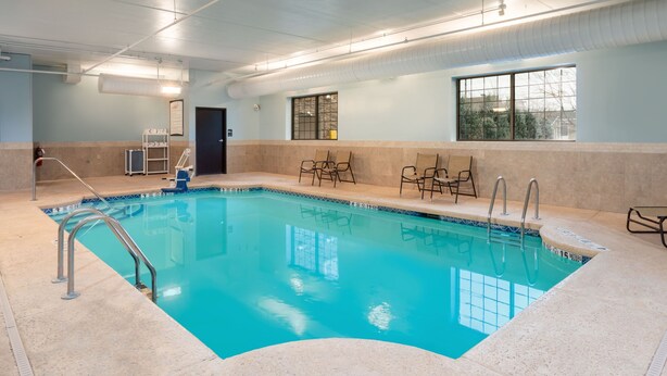 Une piscine intérieure à l’eau claire, dotée d’un poste de surveillance pour le sauveteur et d’une fenêtre offrant une vue agréable.