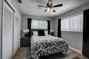 A bedroom with a bed, two bedside tables, a ceiling fan, and a window with blinds. - E. Boca Heated Pool Home/1 Mile to Beach + Mizner (Boca Raton)