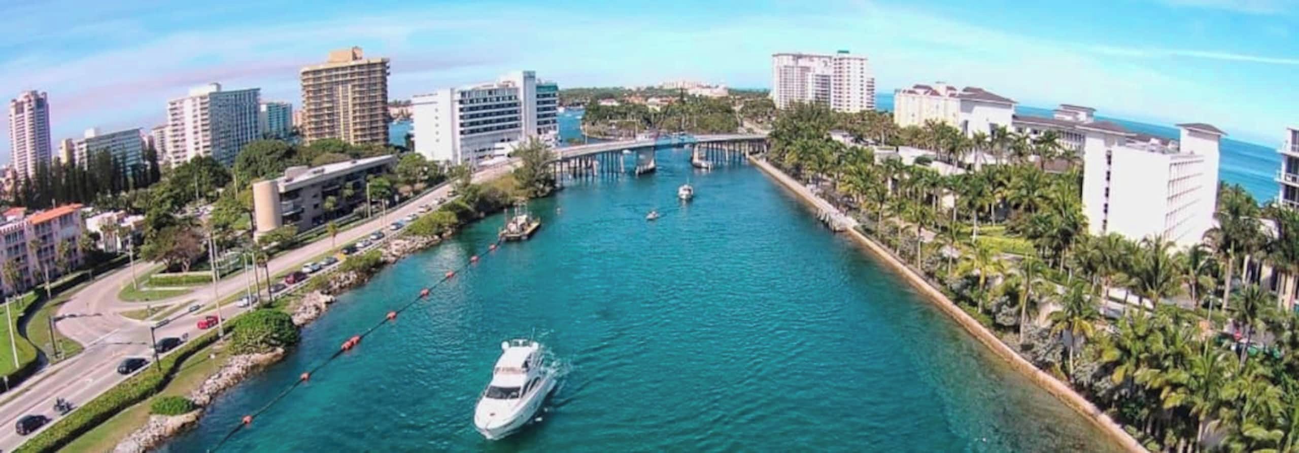 A river with boats, a bridge, and buildings along the riverbanks.