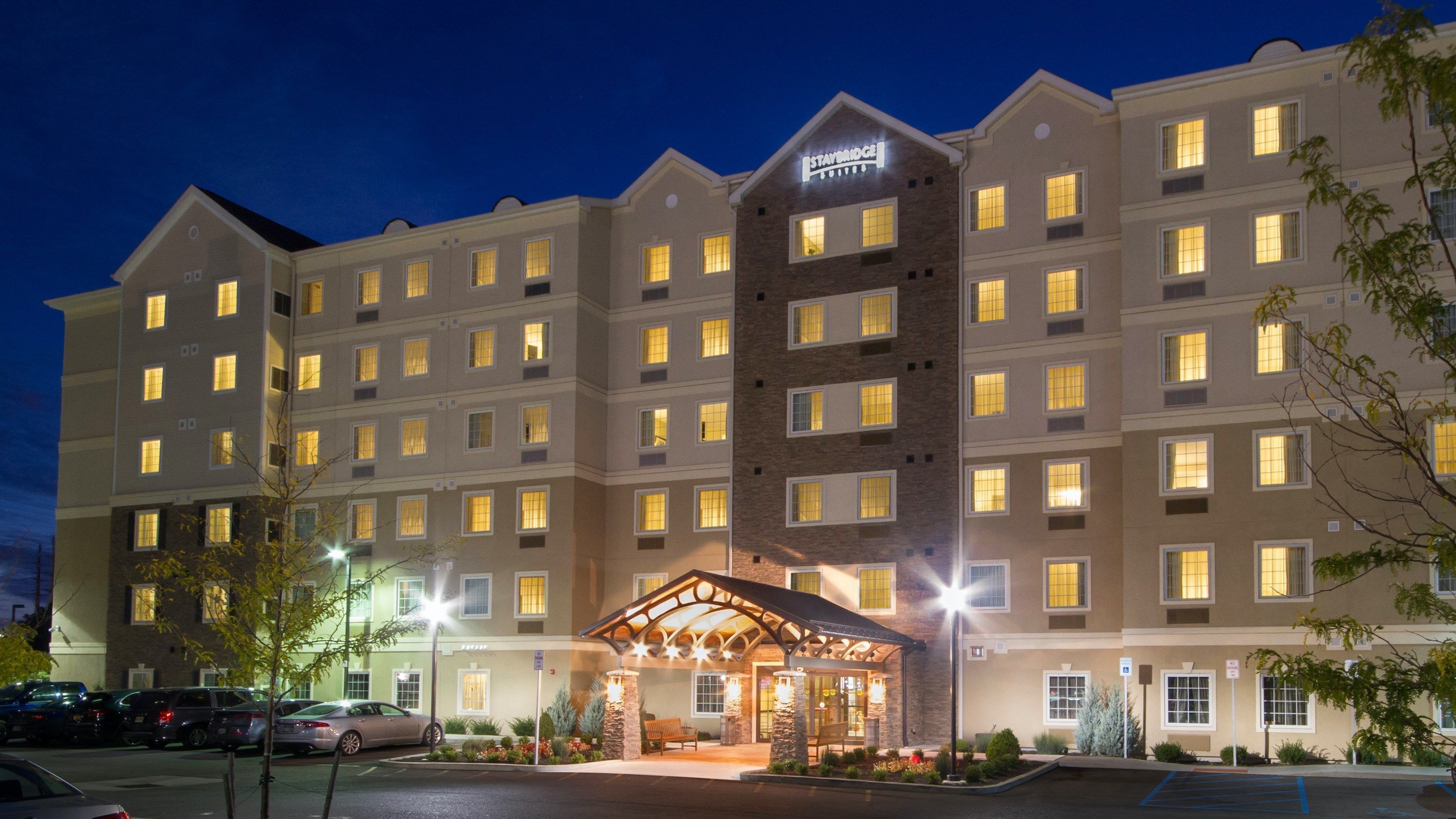 A multi-story hotel with a central entrance and a covered outdoor area.