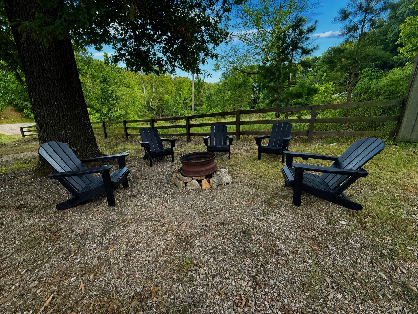 Een terras met Adirondack-stoelen rond een vuurkuil.