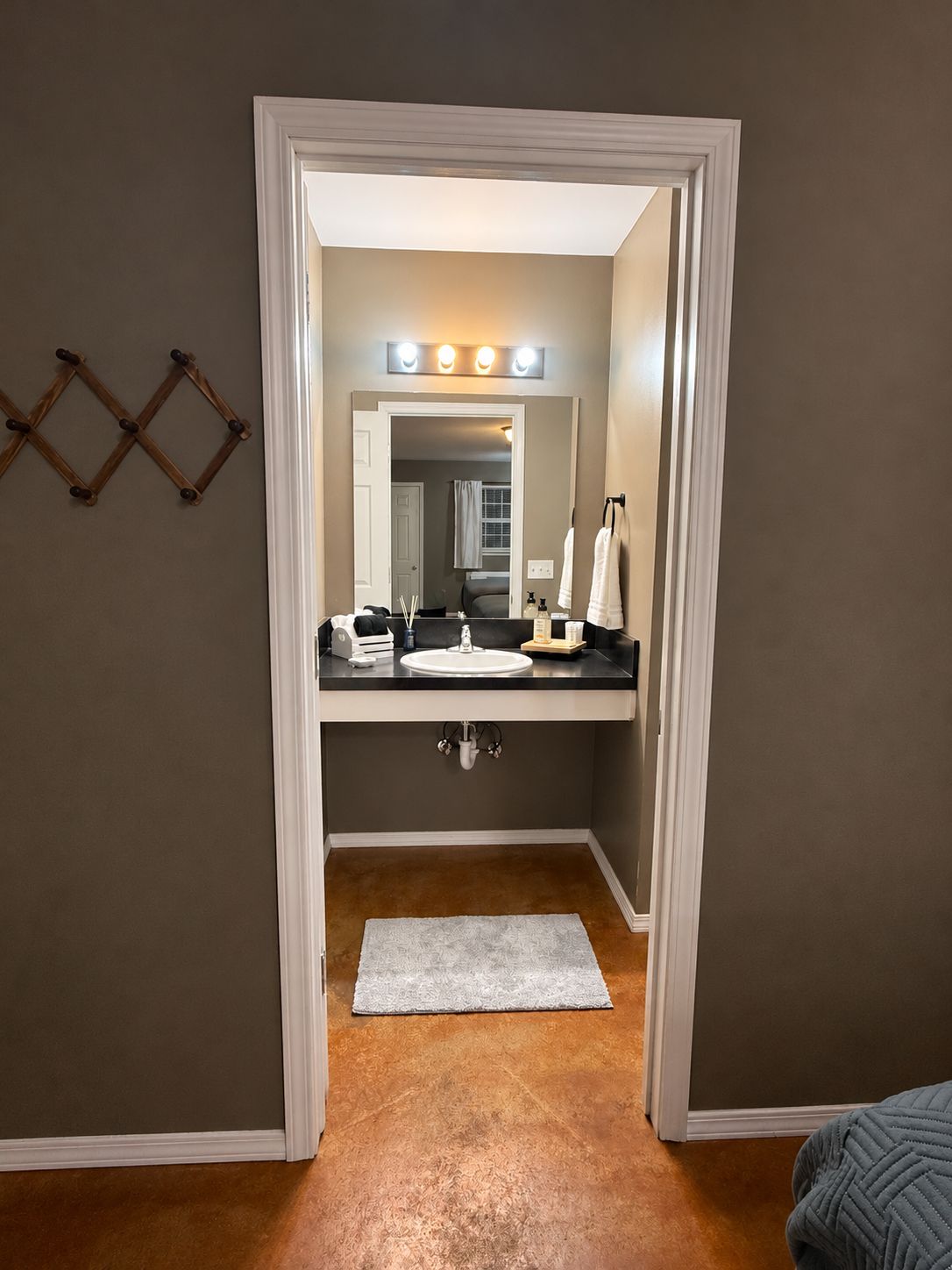 A bathroom with a vanity, mirror, and lighting.