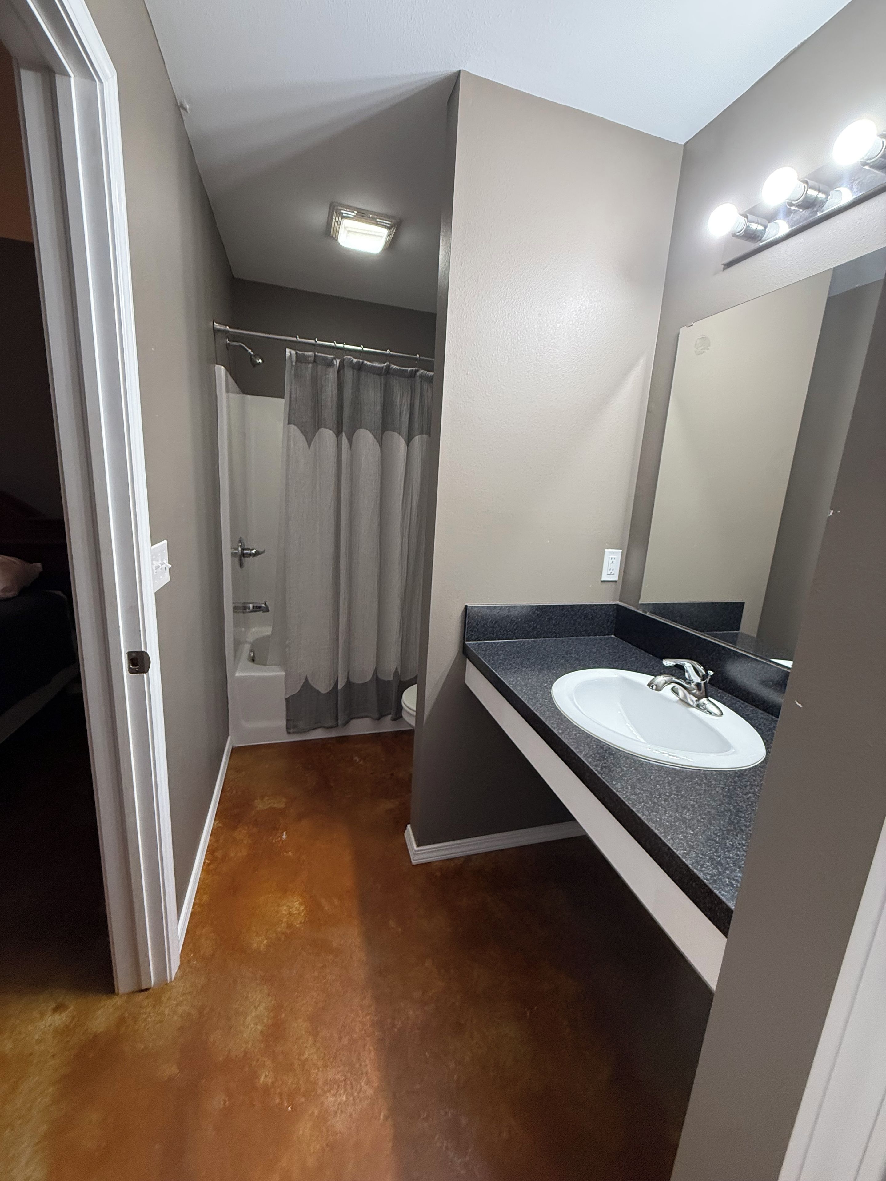 A bathroom with a vanity, a shower, and a toilet.