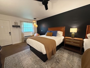 A bedroom with a bed, bedside tables, a lamp, and a ceiling fan. - The Pines 2 — Updated River Lodge (TAHLEQUAH)