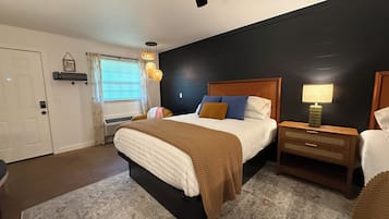 A bedroom with a bed, bedside tables, a lamp, and a ceiling fan.