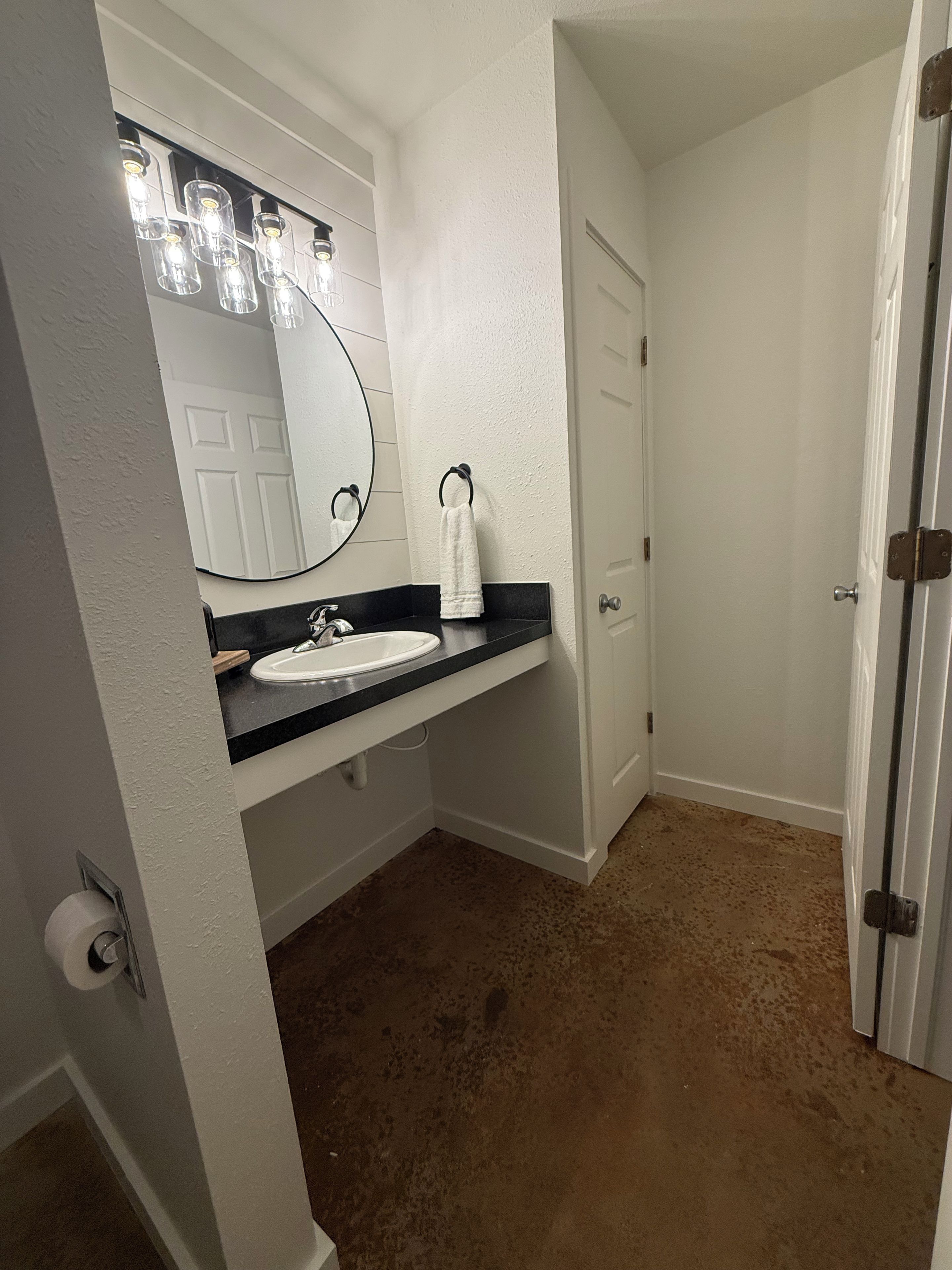 Une salle de bain avec un lavabo blanc, un miroir et un porte-serviettes.