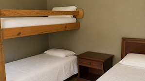 A bunk bed room with a wooden headboard, a bedside table, and a nightstand. - Welcome to The Eddy, our family-friendly room at The Lodge on Ten (TAHLEQUAH)