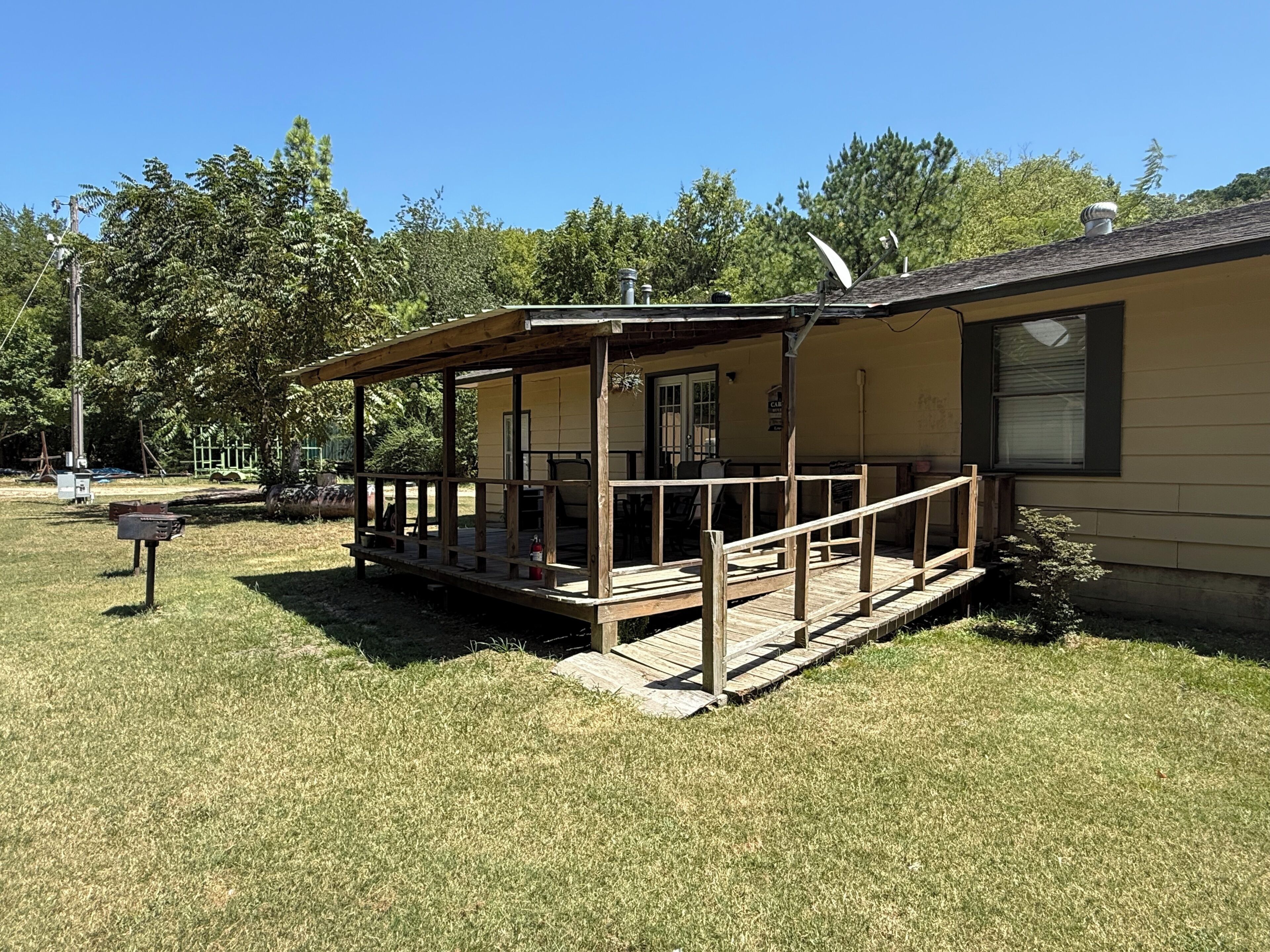 A single-story building with a covered porch and a fenced yard.