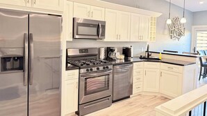 Eine moderne Küche mit Edelstahlgeräten, weißen Schränken und einem eingebauten Backofen.