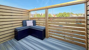Eine Holzterrasse mit integriertem Sitz und Blick auf die Umgebung.