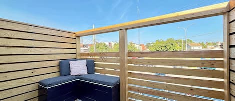 Een houten terras met een ingebouwde bank en uitzicht op de omgeving.