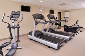 A gym with treadmills, ellipticals, and a stationary bike.