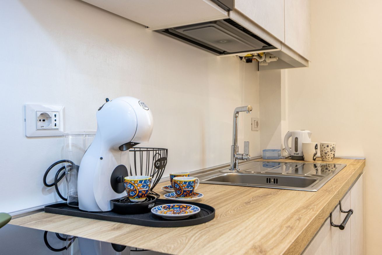 Eine moderne Küche mit Kaffeemaschine, Wasserkocher und Spüle.