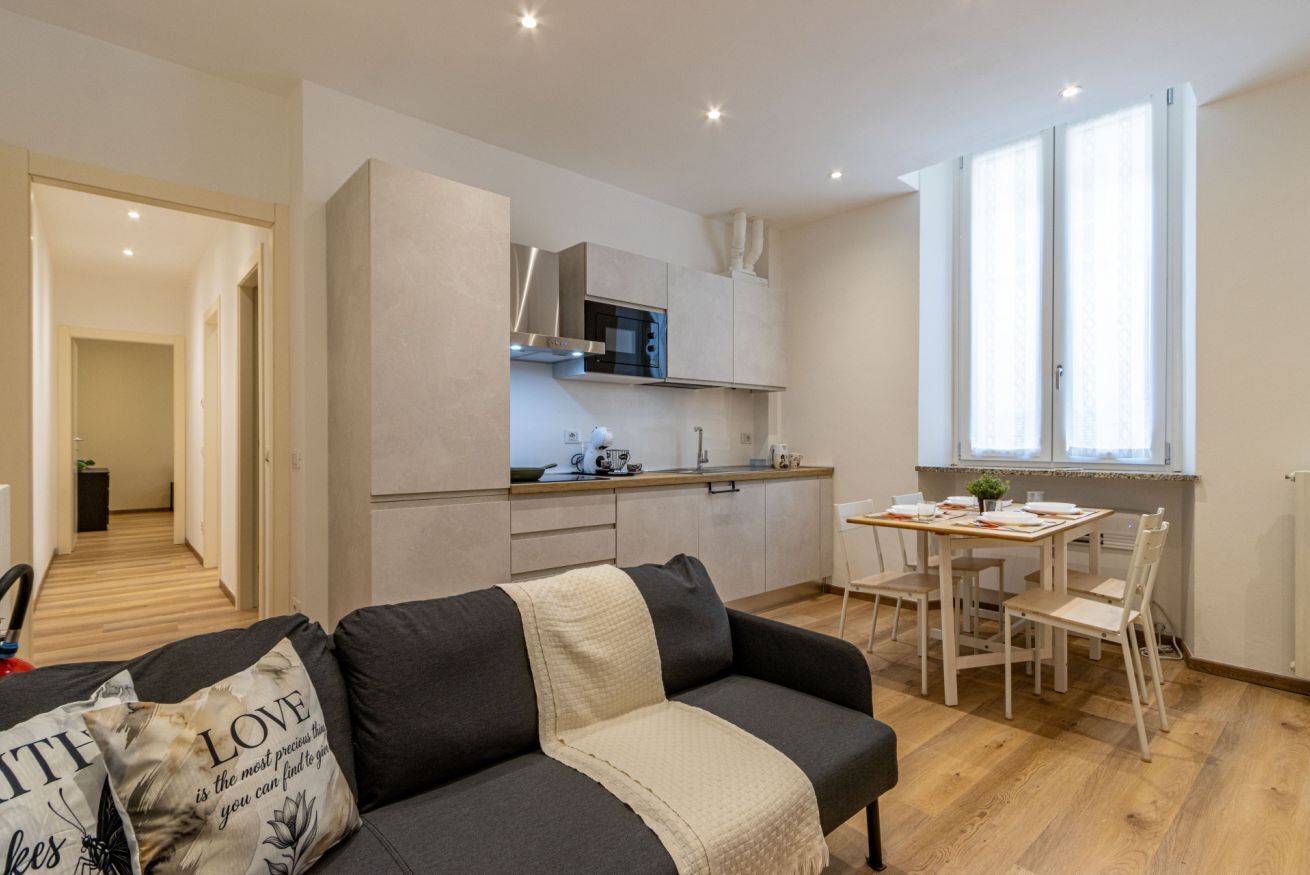 Eine moderne Wohnung mit Wohnbereich, Küchenzeile und Essplatz.