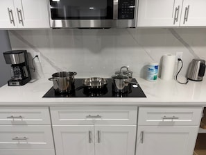 Een koffiezetapparaat/waterkoker, een koelkast, een magnetron