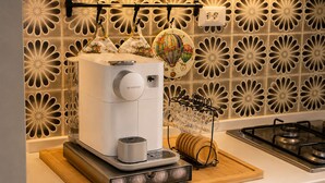 Eine Küche mit Kaffeemaschine, einer Weinschlange und einer dekorativen Spritzschutzwand.