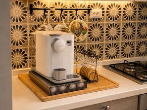 Eine Küche mit Kaffeemaschine, einer Weinschlange und einer dekorativen Spritzschutzwand.