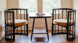 A room with a sloped ceiling, two windows, a table, and two chairs. - Frida's House, Art-Filled Victorian in the Heart of Detroit (Detroit)