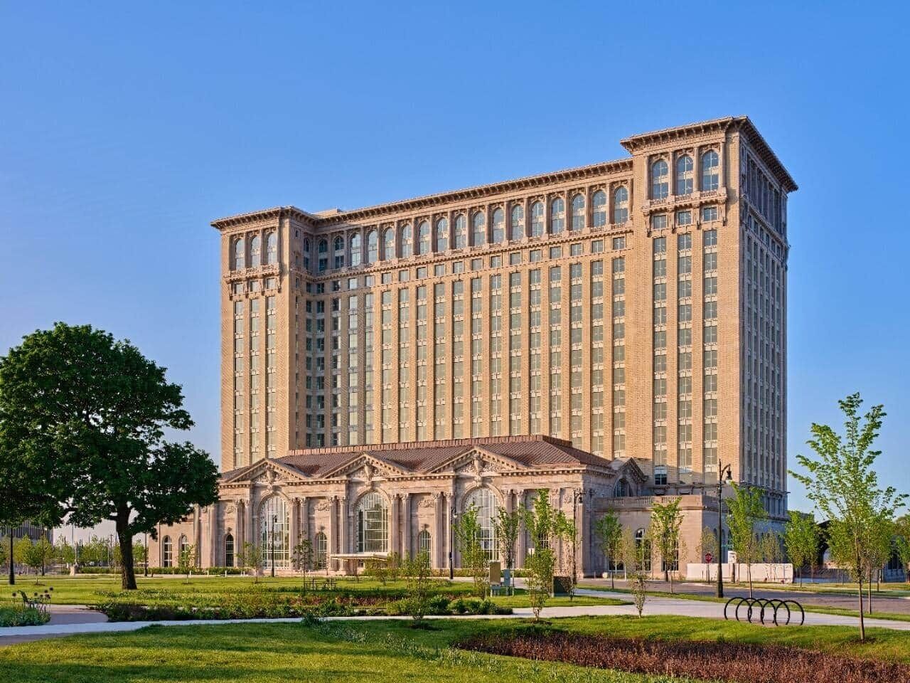 A large, multi-story building with a symmetrical facade, featuring a central entrance with columns and a flat roof.