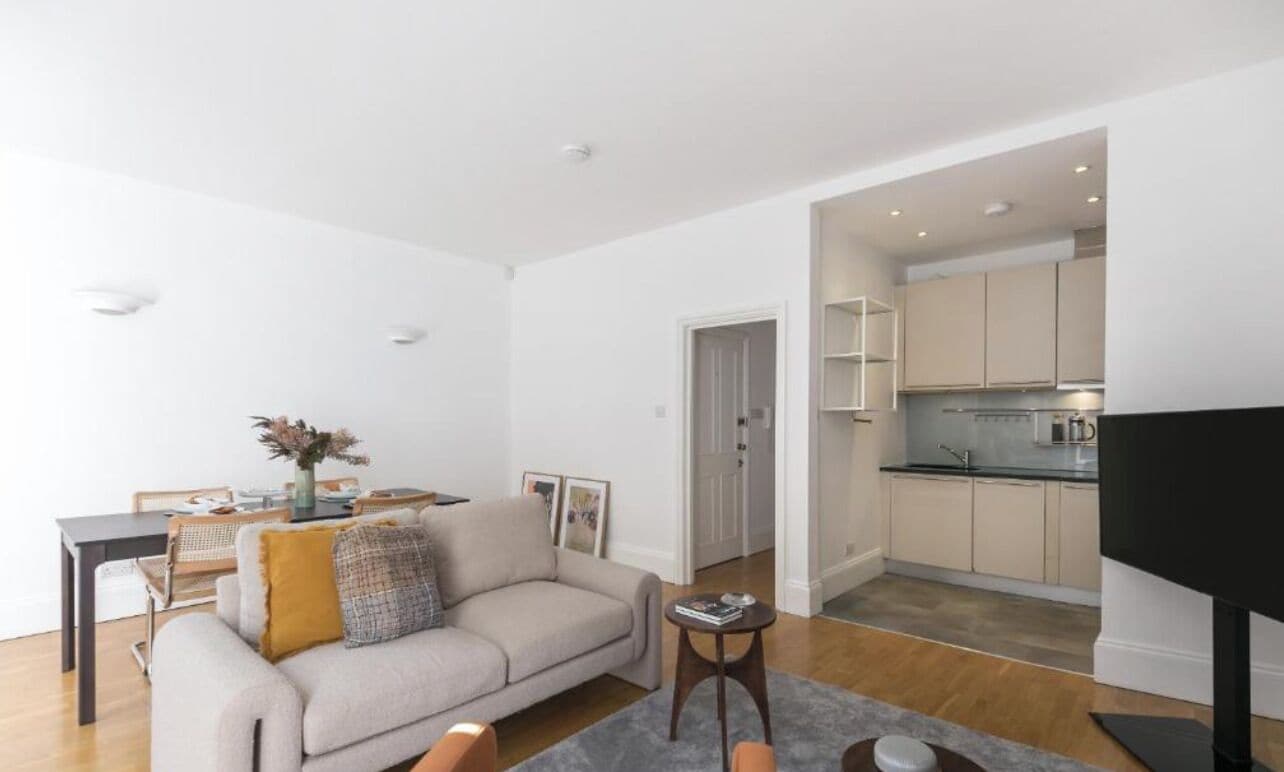 Uma sala de estar moderna com sofá, mesa de centro e área de jantar.