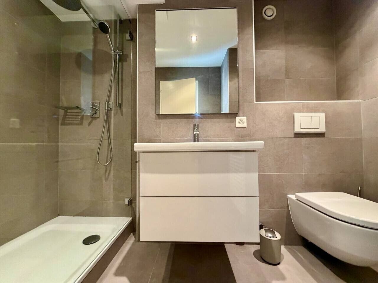 Ein modernes Badezimmer mit Dusche, Toilette und Waschtisch.