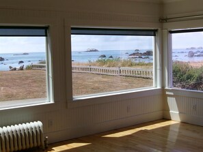 A room with large windows overlooking a beach with rocks and a fence. - The Lighthouse! Ocean front bluff. (Crescent City)