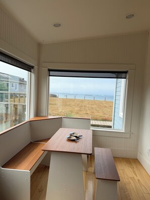 A room with a large window offering a view of the beach and ocean. - The Lighthouse! Ocean front bluff. (Crescent City)