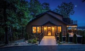 A two-story wooden house with a balcony, surrounded by trees. - NEW Dolly Fireworks View! 3 King, LuxHotTub, Fence Yd (Pigeon Forge)