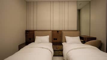 A hotel room with two beds, a wooden headboard, a mirror, and a skylight.