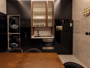Una cocina moderna con horno empotrado, lavamanos y refrigerador.